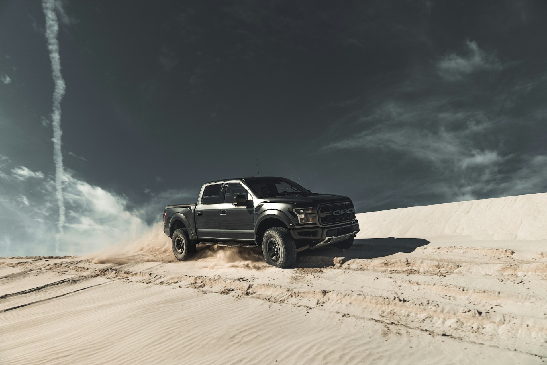 Black pickup truck on desert sand