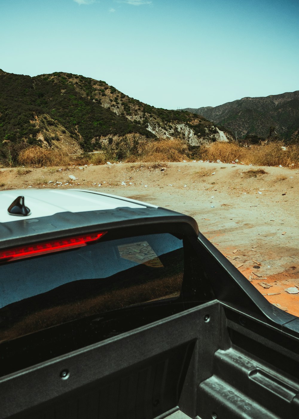 View over the cab into a black-lined pickup truck bed