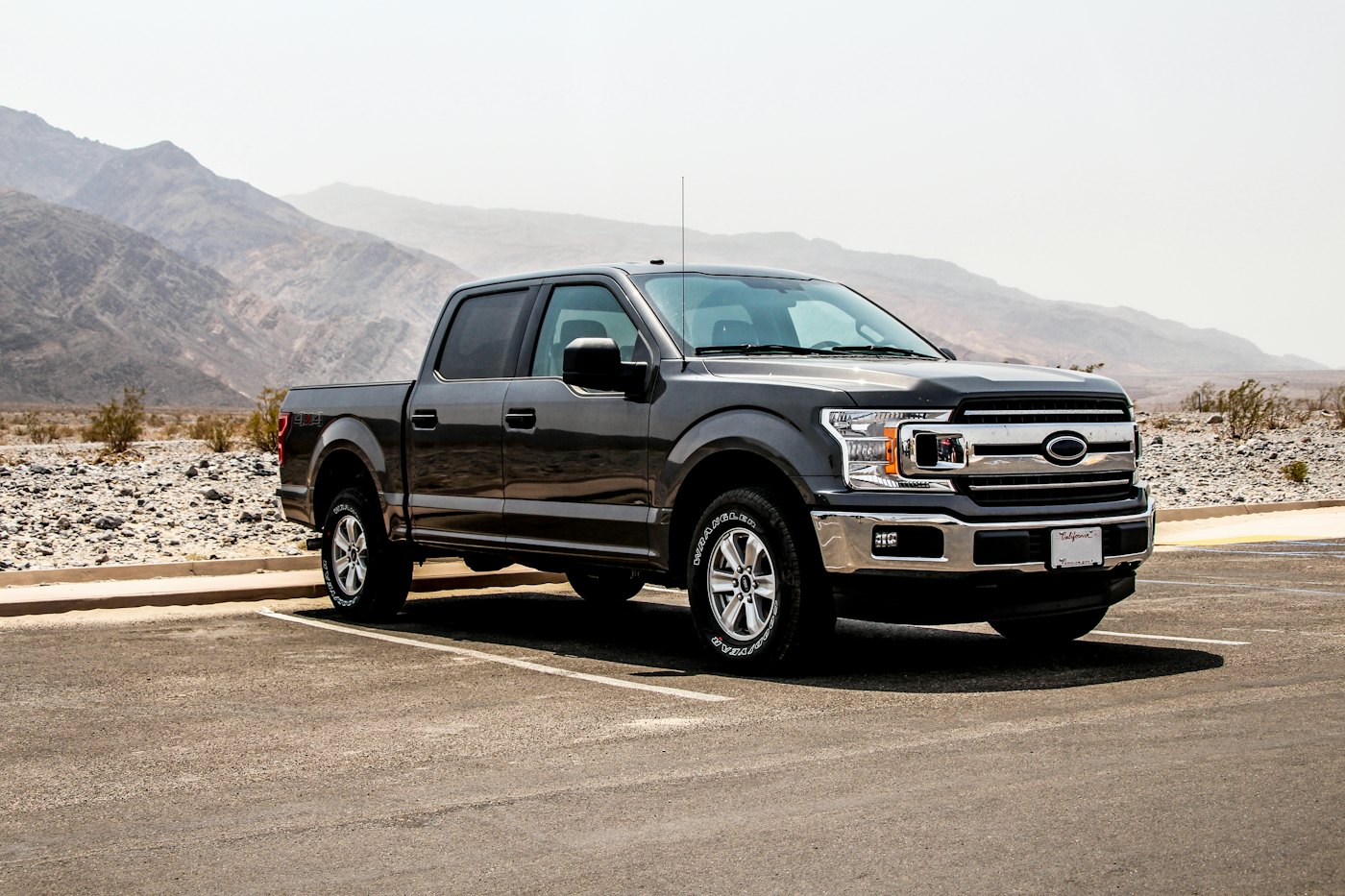 Black pickup truck parked with mountains in the background