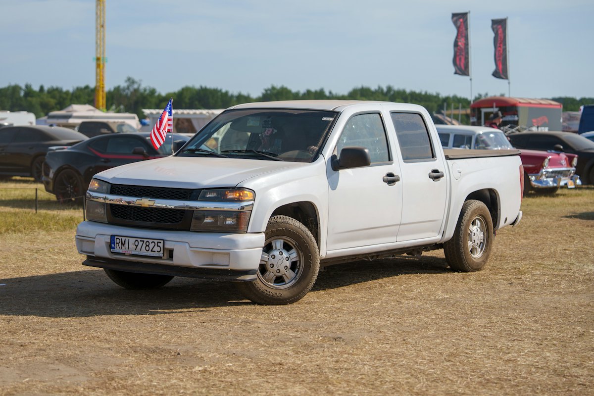 White pickup truck parked on a dirt field